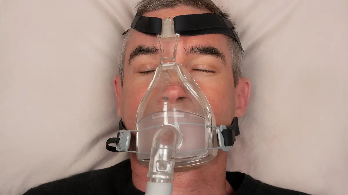 Man with sleep apnea and CPAP machine