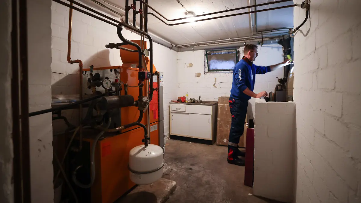 ARCHIV - 09.11.2021, Schleswig-Holstein, Itzehoe: Ein Mitarbeiter eines Diesel- und Heizöl-Unternehmens prüft die beiden Kunststofftanks einer Heizung in einem Heizungskeller bei der Heizöllieferung für ein Einfamilienhaus. (Zu dpa "Ampel-Streit um Heizungsgesetz reißt nicht ab") Foto: Christian Charisius/dpa +++ dpa-Bildfunk +++