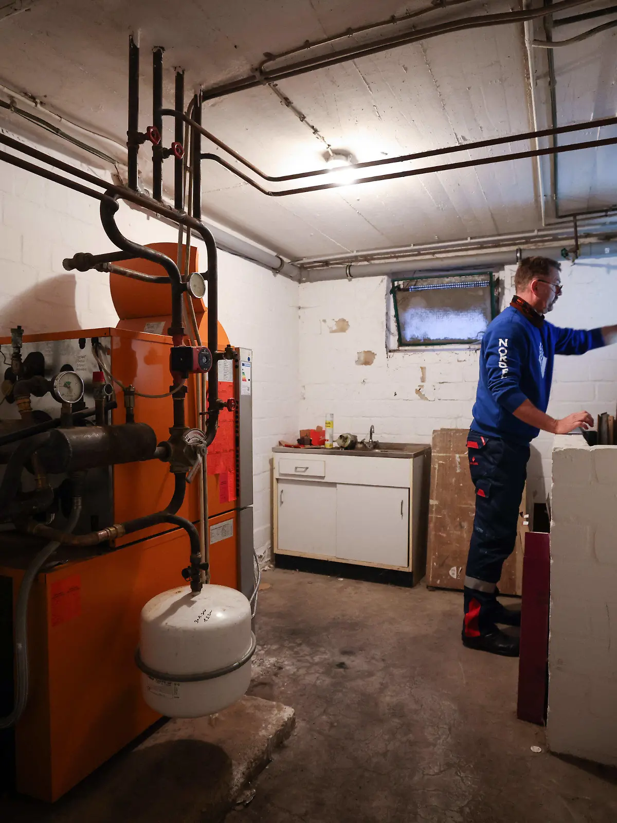 ARCHIV - 09.11.2021, Schleswig-Holstein, Itzehoe: Ein Mitarbeiter eines Diesel- und Heizöl-Unternehmens prüft die beiden Kunststofftanks einer Heizung in einem Heizungskeller bei der Heizöllieferung für ein Einfamilienhaus. (Zu dpa "Ampel-Streit um Heizungsgesetz reißt nicht ab") Foto: Christian Charisius/dpa +++ dpa-Bildfunk +++