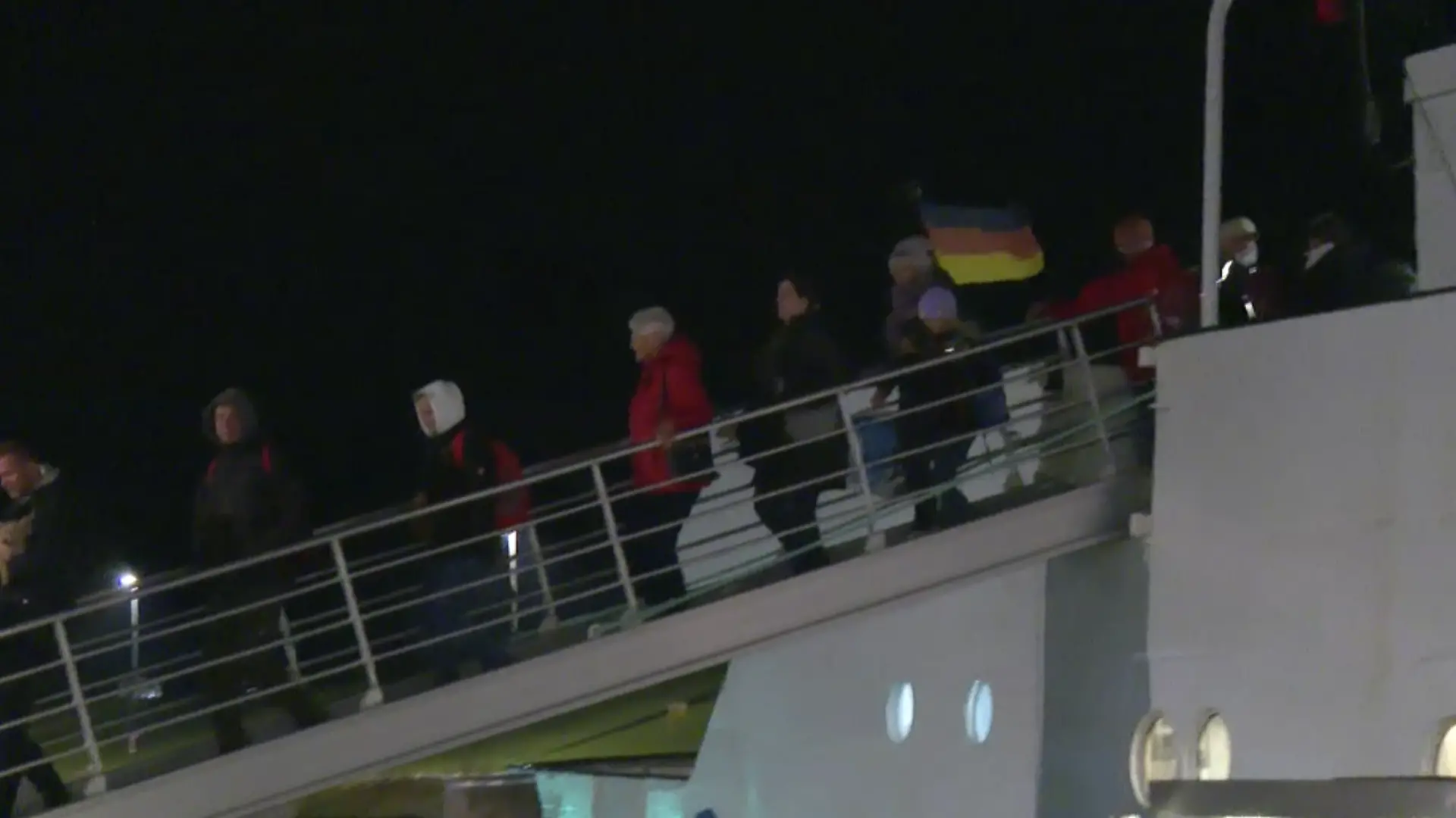 Menschen gehen über eine Brücke von Bord eines Schiffes.