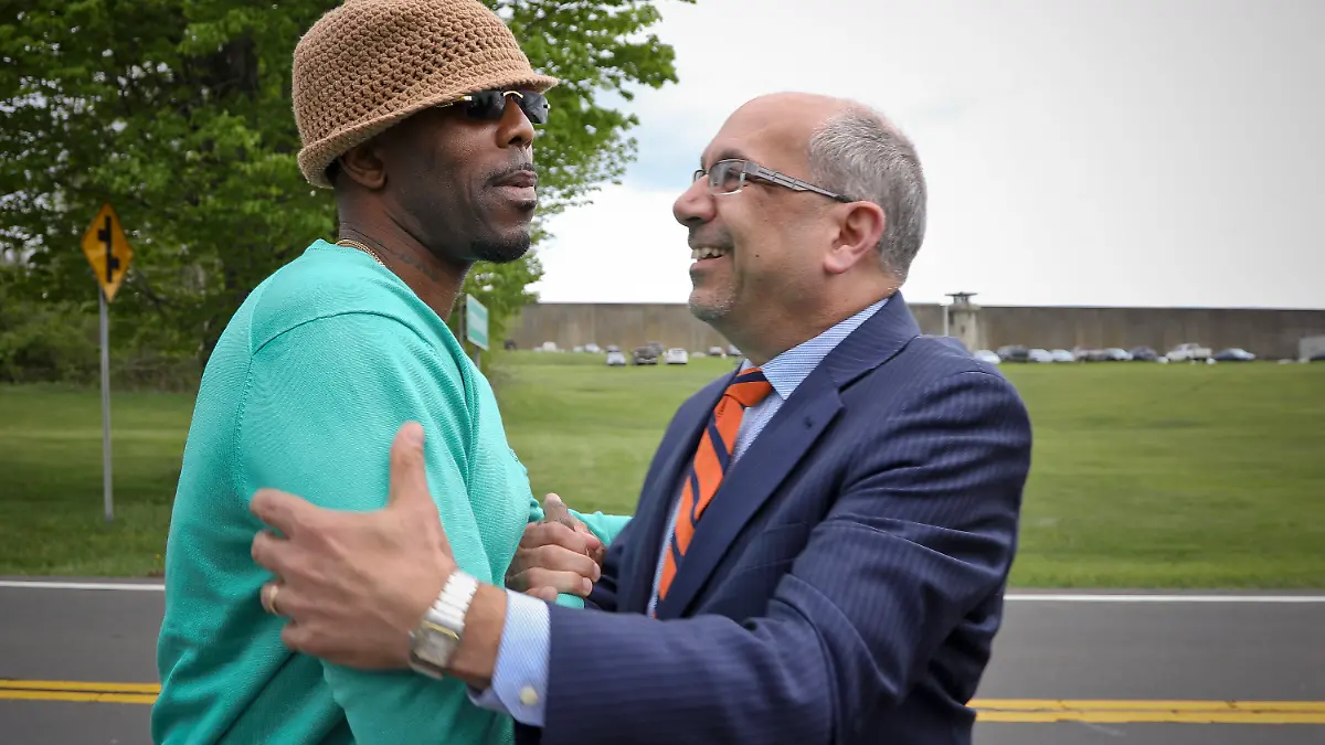 FILE - In this May 8, 2017, file photo, Calvin Buari, left, is embraced by his lawyer Oscar Michelen following Buari’s release from Green Haven correctional facility, shown in background, in Stormville, N.Y. Prosecutors dropped charges Wednesday, March 21, 2018, against Buari who spent 22 years in prison for a double killing before new witnesses came forward and his conviction was overturned. The decision came after a judge had already overturned Buari’s conviction and freed him in May. 