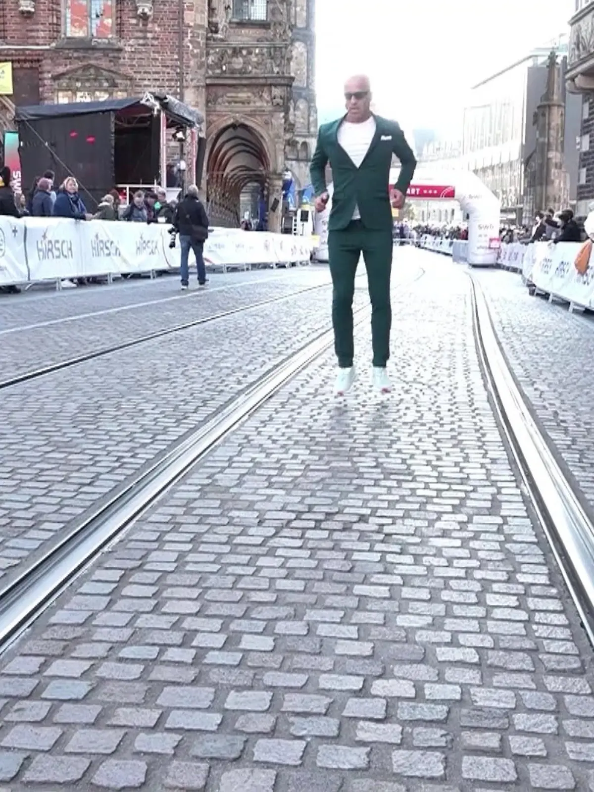 Mit kleinen Sprüngen hüpft Emin da Silva ins Ziel und das sogar im Anzug. 