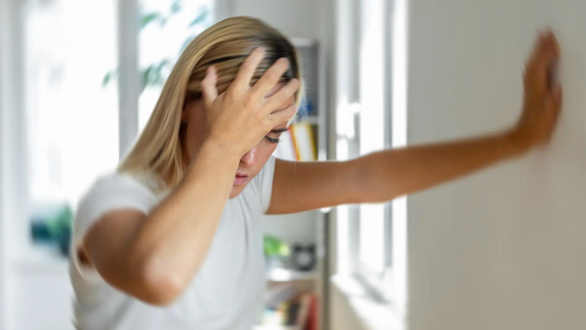 Eine Frau fasst sich an den Kopf. 