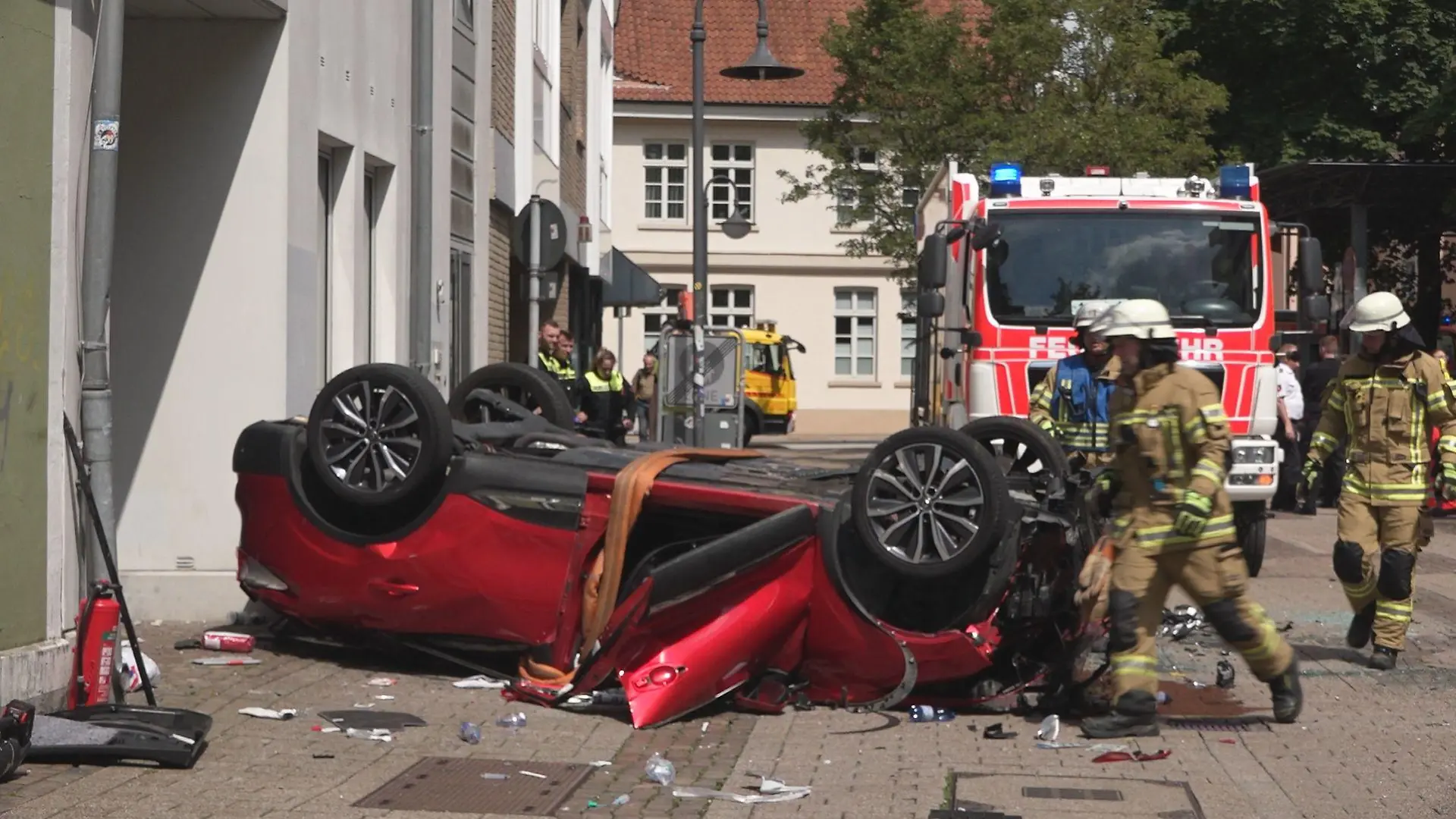30.06.2023, Oldenburg: Vor einem Parkhaus liegt ein Auto auf dem Dach. Der Wagen war aus dem vierten Stock des Parkhauses auf die Straße gefallen. (zu dpa: «81-Jährige stürzt in Oldenburg mit Auto von Parkdeck und stirbt») Foto: Andre van Elten/TV7News/dpa +++ dpa-Bildfunk +++