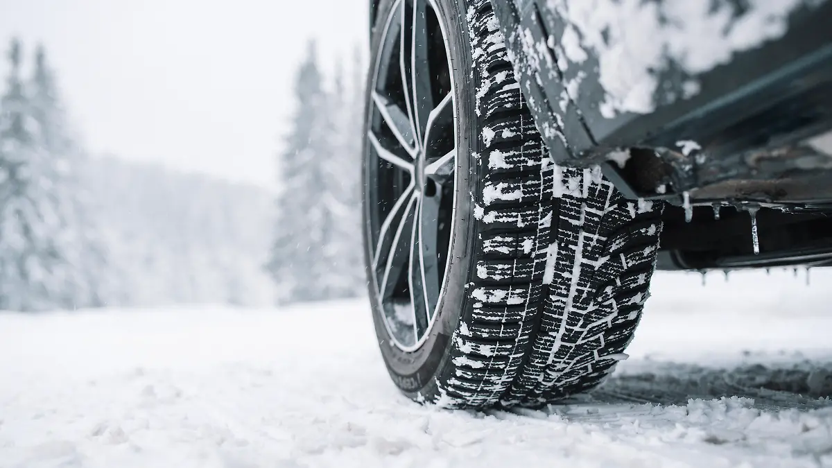 Ein nahes Foto eines Autoreifen auf dem Schnee.