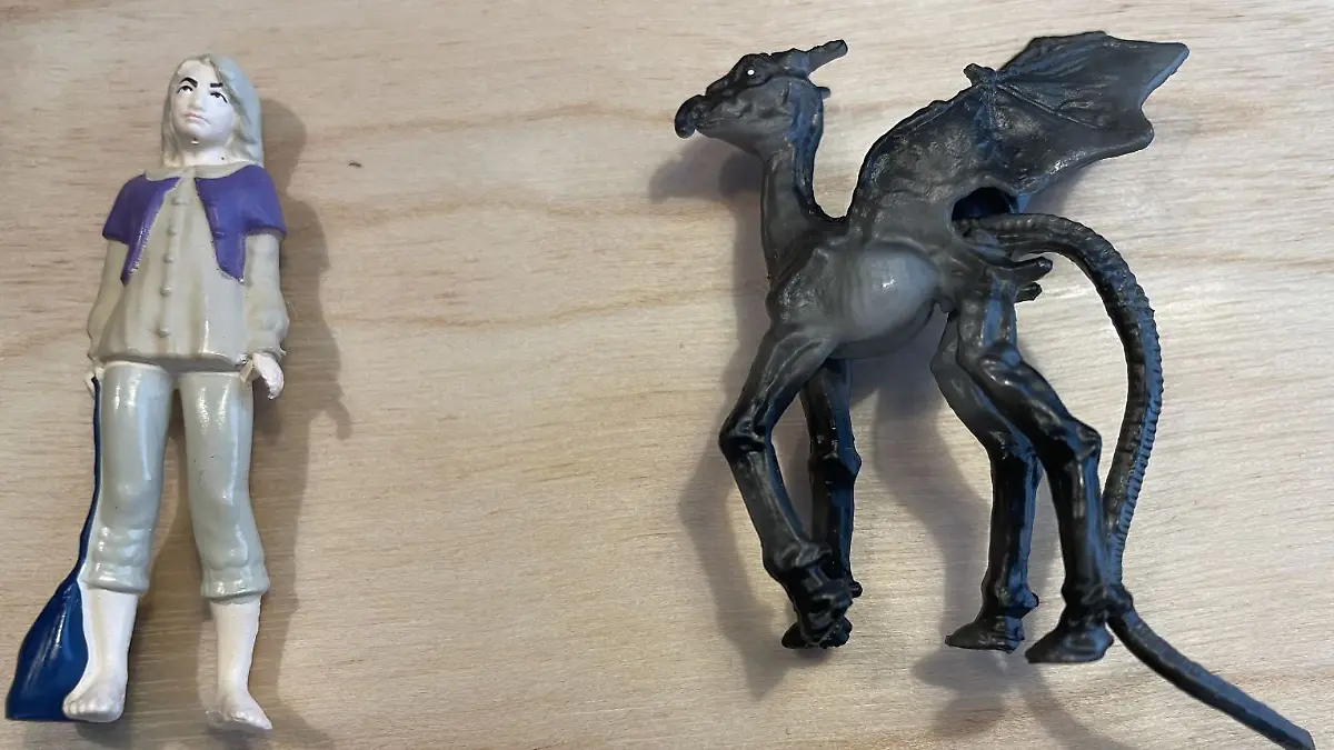 Spielfiguren Luna Lovegood und Thestral liegen nebeneinander auf einem Tisch.
