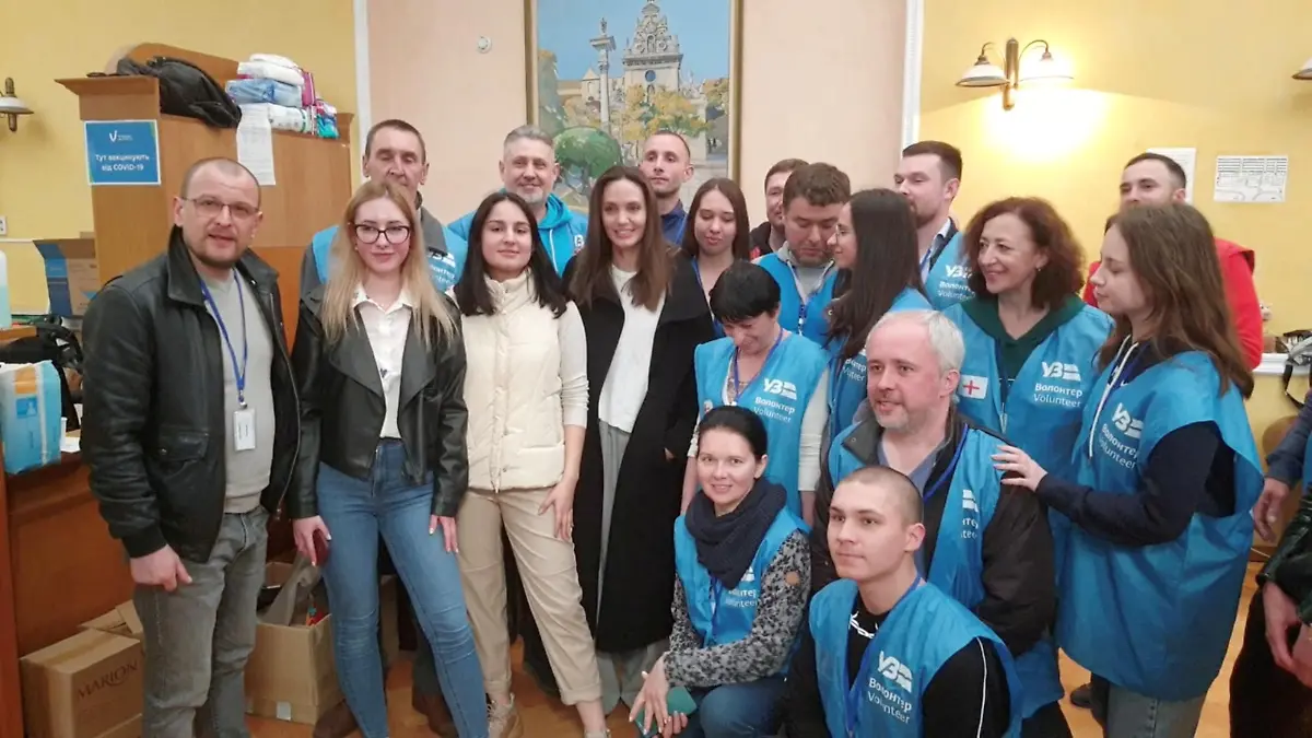U.S. actor and UNHCR Special Envoy Angelina Jolie prepares for a group photo with volunteers as she visits Lviv's main railway station, amid Russia's invasion of Ukraine April 30, 2022 in this image obtained from handout video. Ukrzaliznytsia/Handout via REUTERS ATTENTION EDITORS - THIS IMAGE HAS BEEN PROVIDED BY A THIRD PARTY. MANDATORY CREDIT.