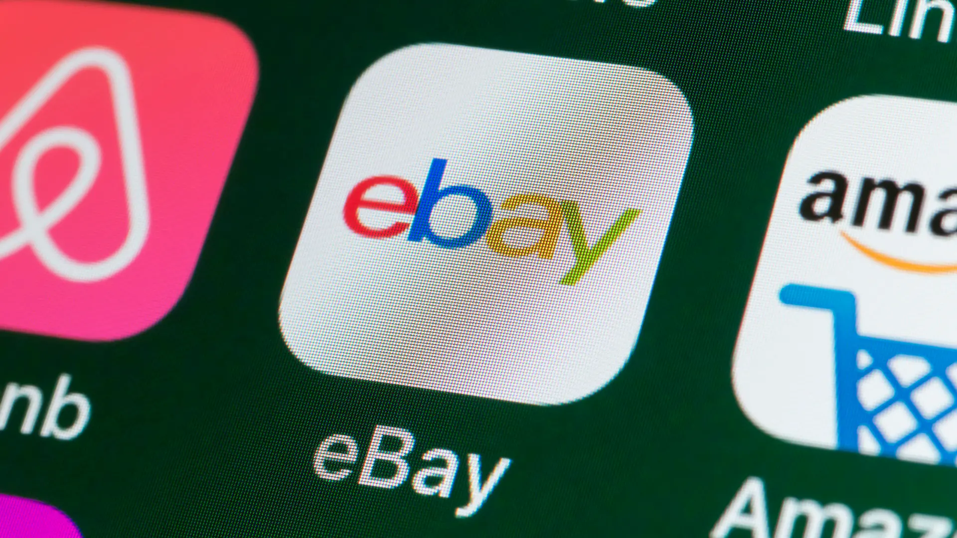 London, UK - July 31, 2018: The buttons of the online shopping app ebay, surrounded by Airbnb, Amazon, News and other apps on the screen of an iPhone.
