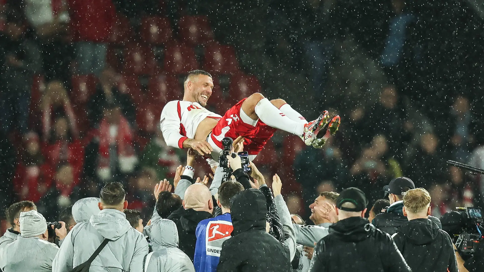 Lukas Podolski wird nach dem Spiel von seinen Mitspielern hochgeworfen Köln