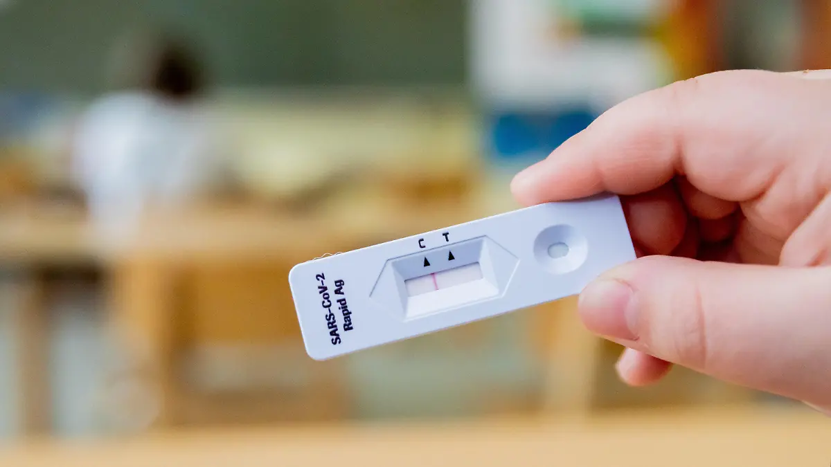 ARCHIV - 14.04.2021, Berlin: ILLUSTRATION - Ein Schüler hält bei einem Probelauf mit Corona-Schnelltests an der Grundschule in der Köllnischen Heide in Berlin-Neukölln seinen negativen Test in die Kamera. (zu dpa: «Nach Masken-Aus nun auch Ende von Corona-Tests an Schulen») Foto: Christoph Soeder/dpa +++ dpa-Bildfunk +++