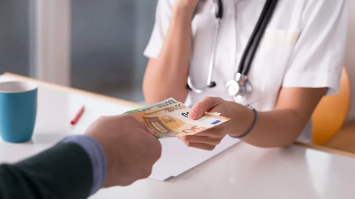 Mann zahlt Geld beim Arzt. 