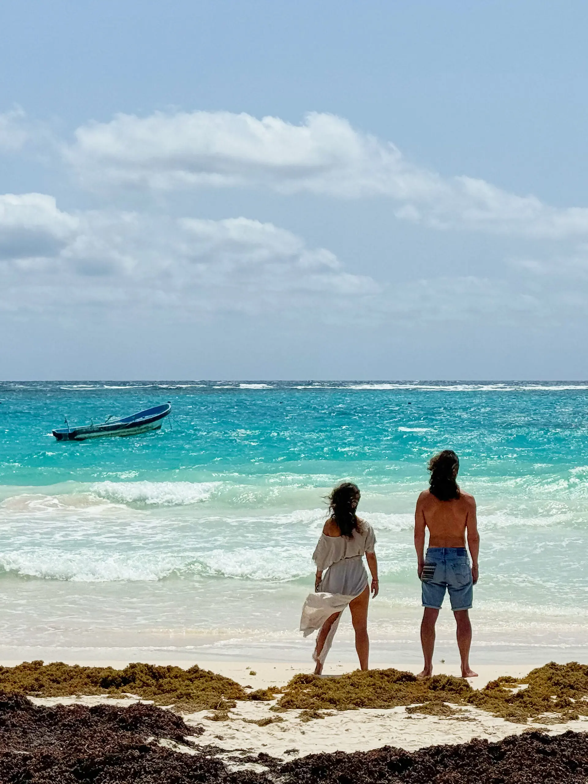Frau und Mann schauen in Tulum/Mexiko auf das karibische Meer. 