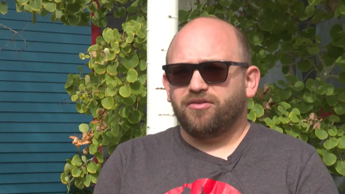 Ein Mann mit Sonnenbrille im Interview.