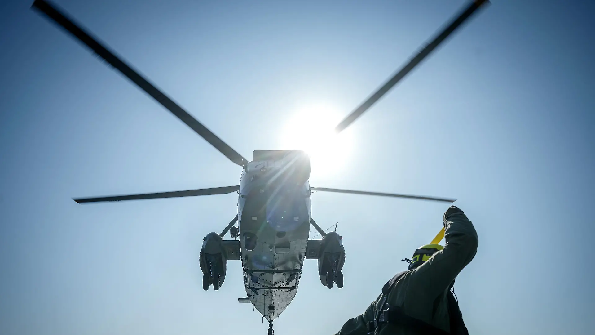 Der Deckchief weist auf der Fregatte "Mecklenburg-Vorpommern" einen Sea King Helikopter der Marine vor dem Besuch des Bundeskanzlers ein.