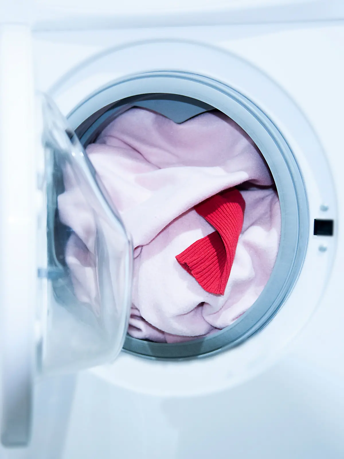 Weiße Wäsche, die durch eine rote Socke in der Waschmaschine auf einmal rosa ist.