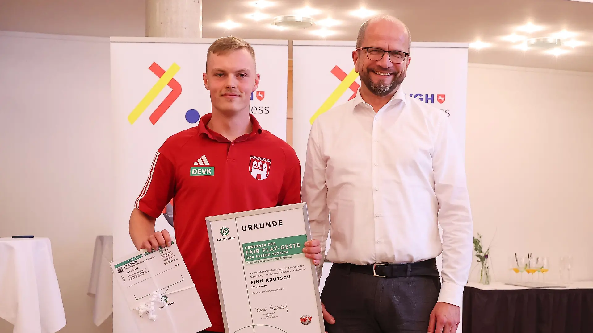 Finn Krutsch (links) erhält vom Vizepräsidenten des niedersächsischen Fußballverbandes Jens Grützmacher die Urkunde für seine Fair-Play-Geste.