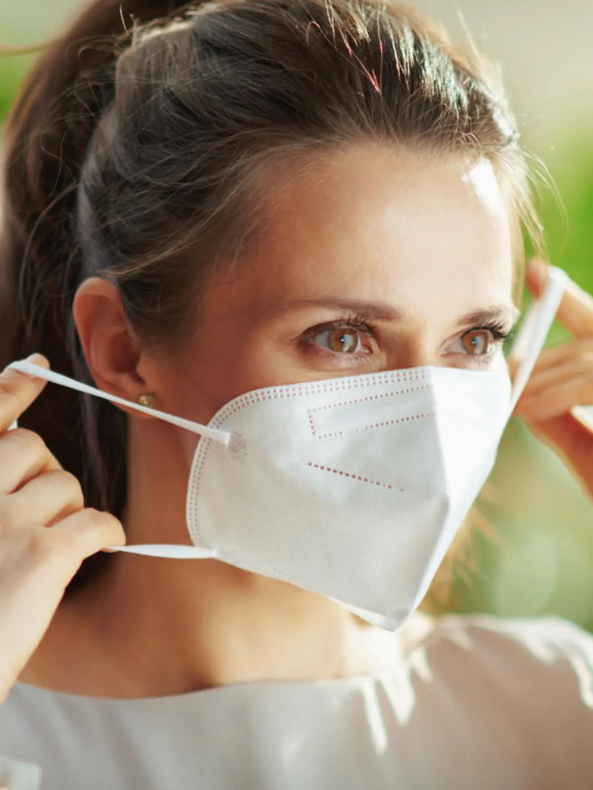 covid-19 pandemic. middle aged woman in grey blouse wearing ffp2 mask.