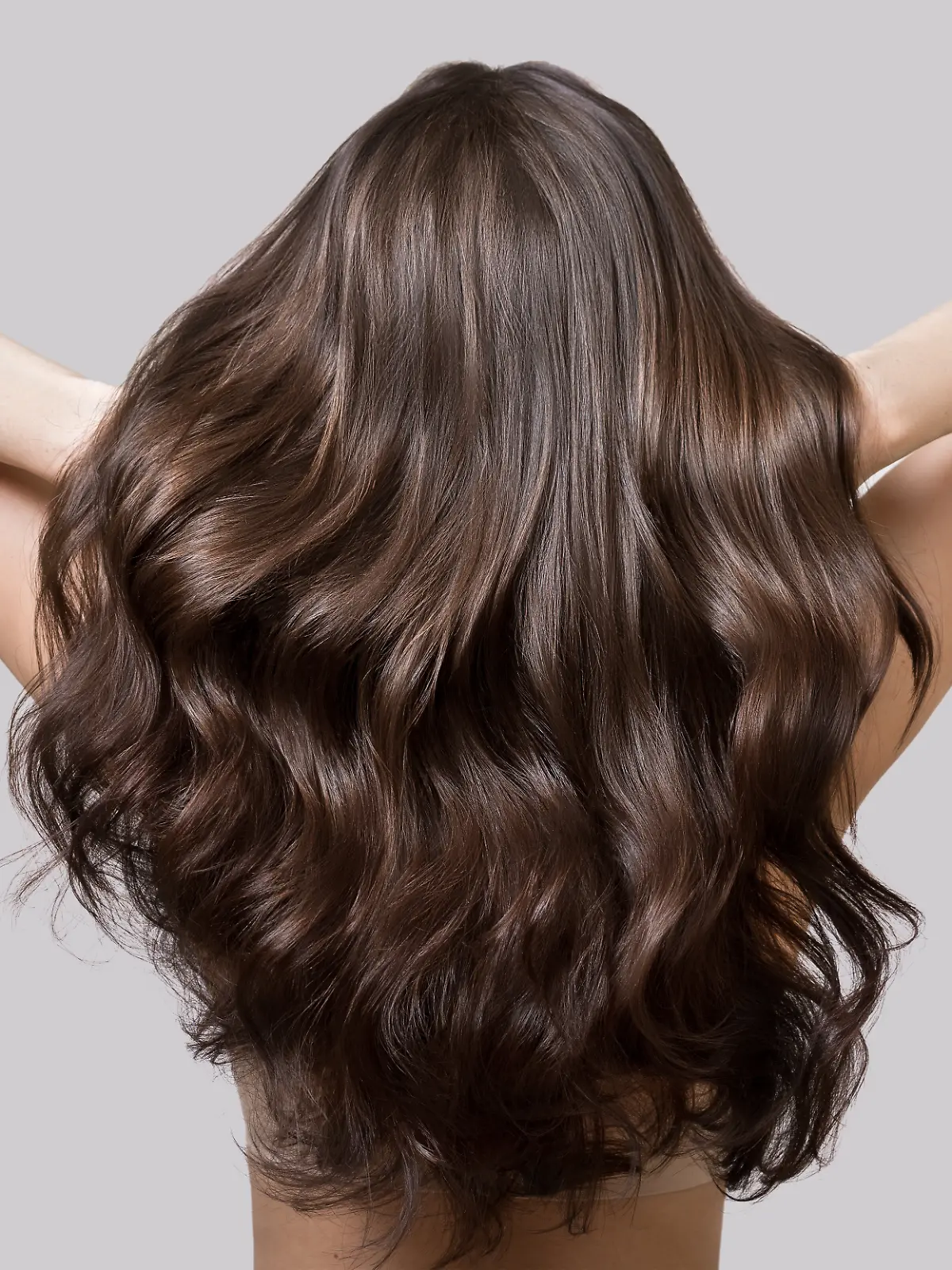 Frau schüttelt ihre Haare nach dem Haarstyling. 