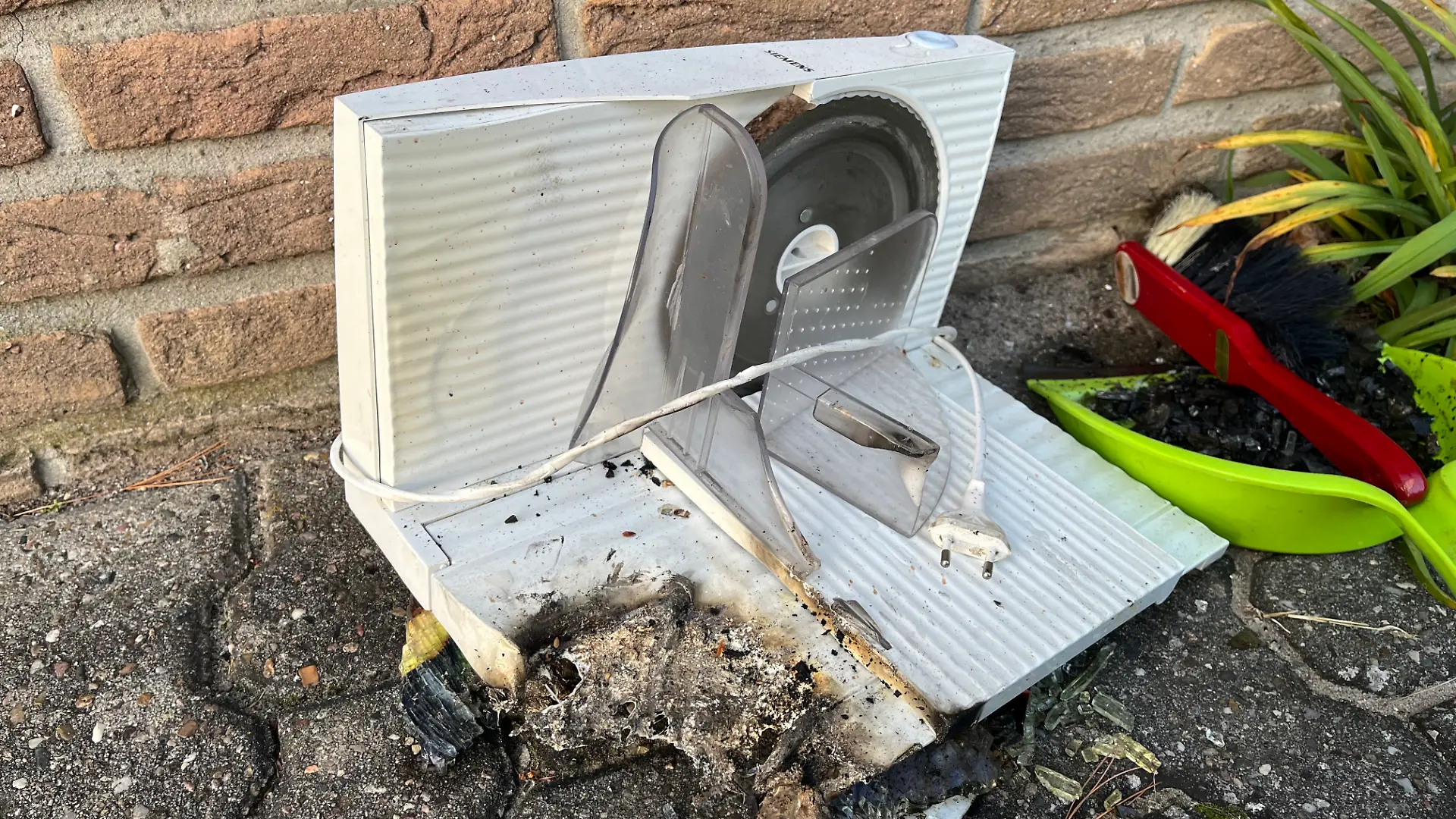 Die brennende Brotschneidemaschine wurde nach dem Ablöschen aus dem Gebäude gebracht.