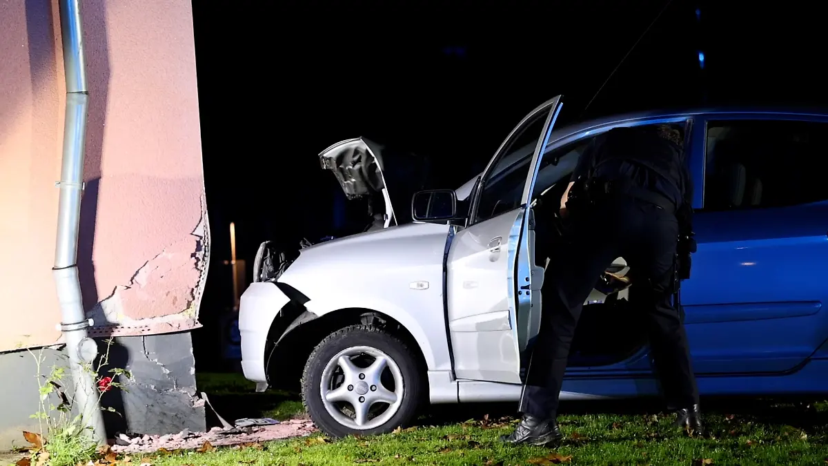 20.10.2024, Nordrhein-Westfalen, Solingen: Ein Polizist untersucht ein Fahrzeug, das gegen eine Hauswand gefahren ist.
Ein betrunkener Autofahrer ist in Solingen von der Straße abgekommen und gegen Hauswand geprallt. Dabei wurde die 18-jährige Beifahrerin leicht verletzt, teilte die Polizei mit. Der Fahrer habe in der Nacht die Kontrolle über das Auto verloren und dabei ein Verkehrszeichen umgefahren, bevor der Wagen gegen die Hauswand prallte. Foto: -/tv7news/dpa +++ dpa-Bildfunk +++