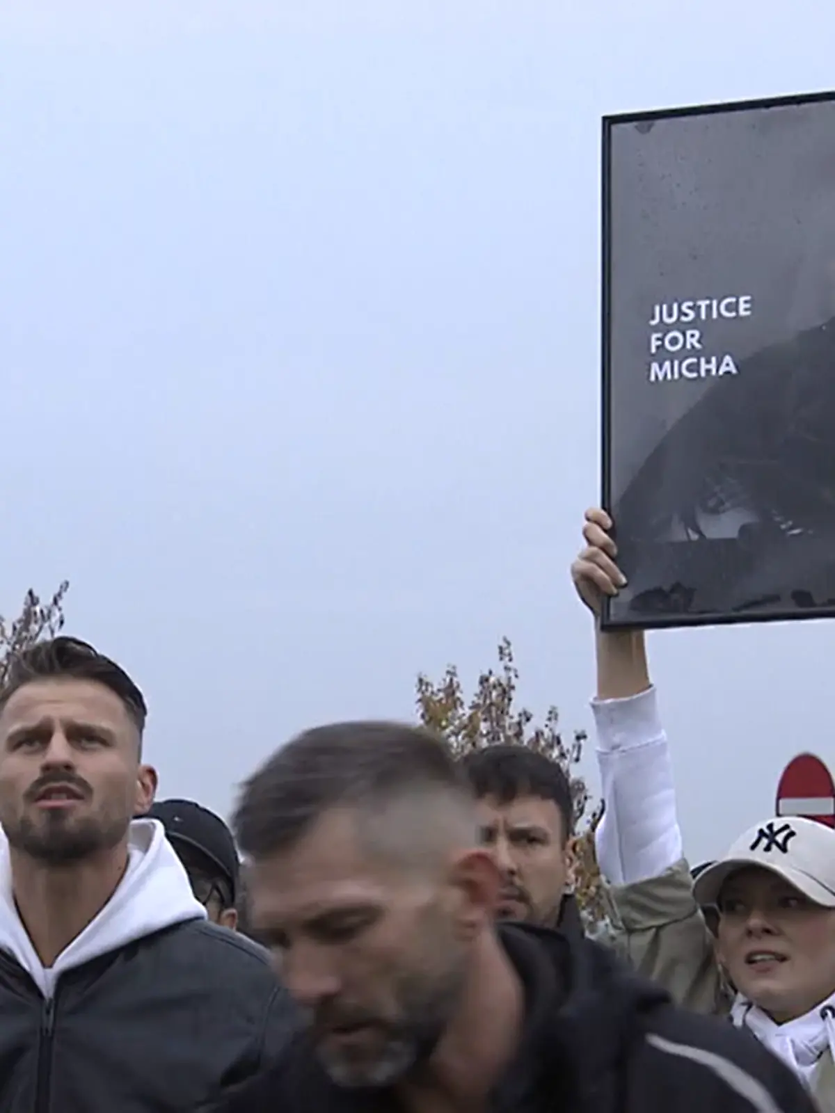 Demonstrierende halten ein Bild des getöteten Micha in die Höhe. Lautstark fordern sie Gerechtigkeit vor den Toren der US-Basis in Rheinland-Pfalz. 