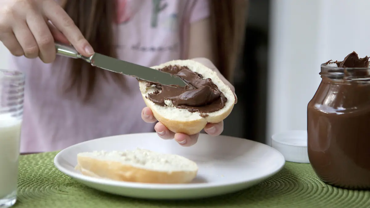 ILLUSTRATION - Ein Maedchen schmiert sich am 10.05.2018 in Berlin ein Nutella-Broetchen. Foto: Silvia Marks | Verwendung weltweit