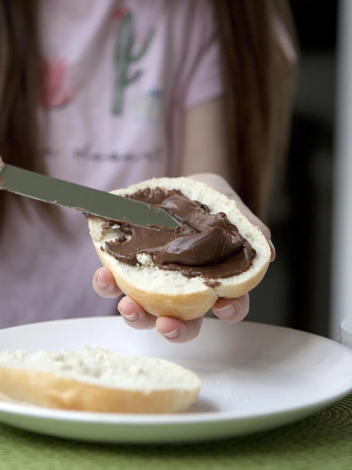 ILLUSTRATION - Ein Maedchen schmiert sich am 10.05.2018 in Berlin ein Nutella-Broetchen. Foto: Silvia Marks | Verwendung weltweit