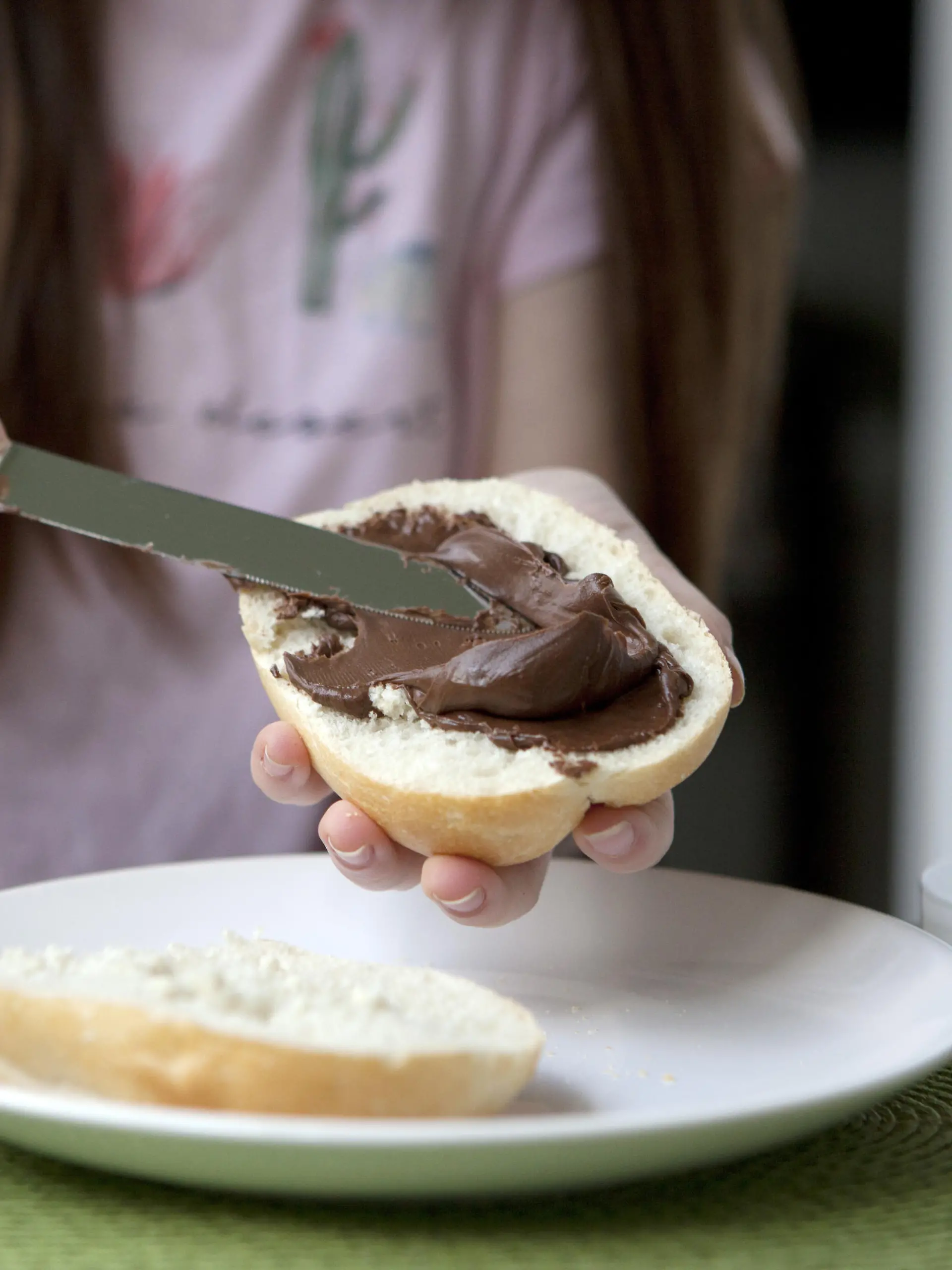 ILLUSTRATION - Ein Maedchen schmiert sich am 10.05.2018 in Berlin ein Nutella-Broetchen. Foto: Silvia Marks | Verwendung weltweit
