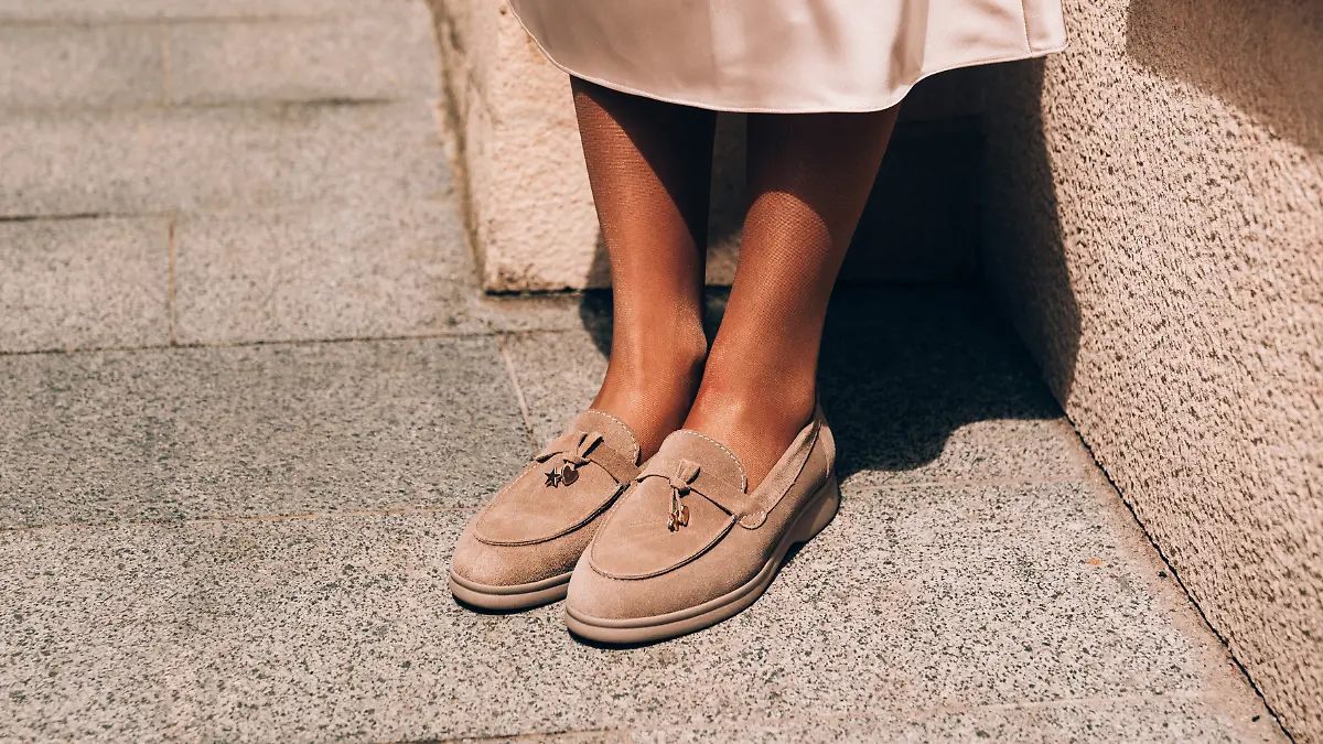 Frau trägt beige Loafer im Herbst.