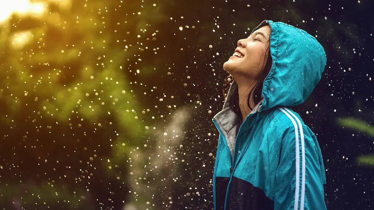 Frau mit Regenjacke im Regen.