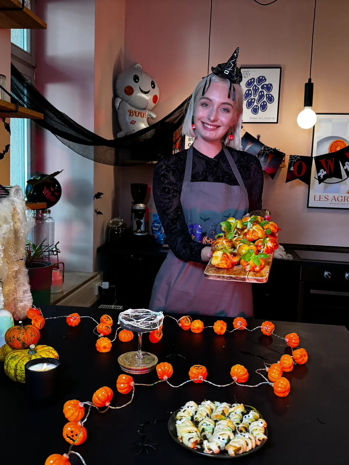 Frau steht am Küchentisch und präsentiert Halloween Rezepte