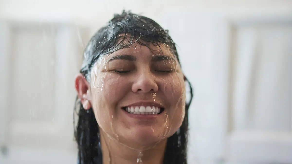 Eine Frau steht unter der Dusche.