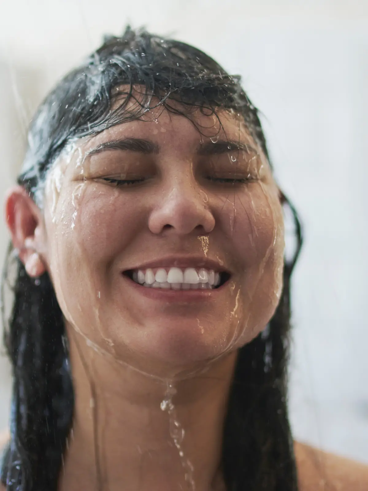 Eine Frau steht unter der Dusche.