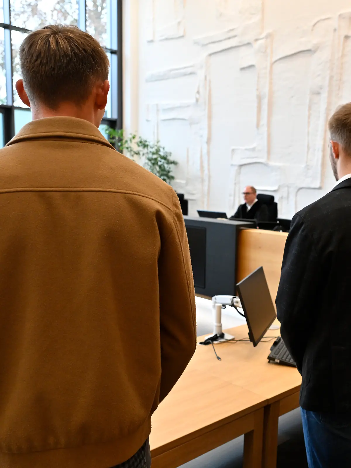 Zwei ehemalige Soldaten der Bundeswehr stehen zu Prozessbeginn wegen gefährlicher Körperverletzung im Saal des Amtsgerichts. Sie sollen einen ehemaligen Kameraden in der Kaserne misshandelt haben.