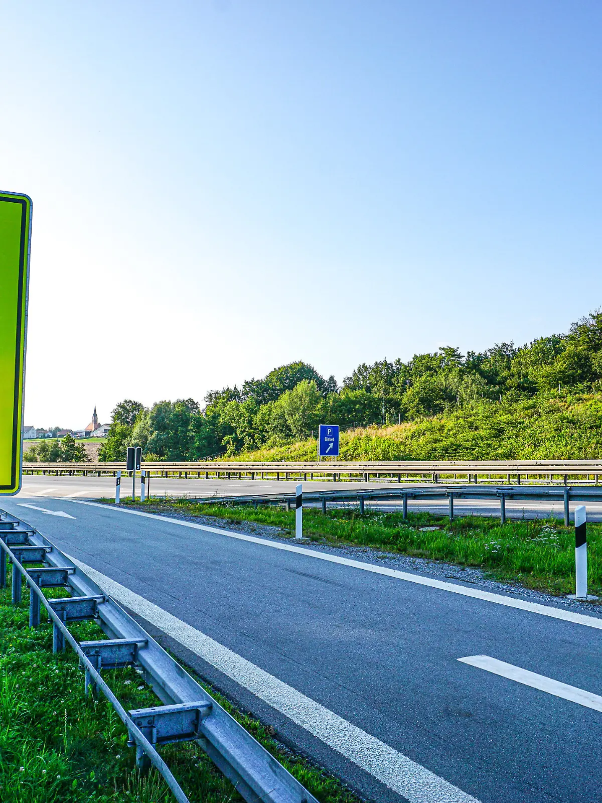 An einer einer Autobahn stehen Warnschilder für einen eventuellen Geisterfahrer, Falschfahrer. Auf den Verkehrsschildern wird darauf hingewiesen, dass der Fahrer in den Gegenverkehr fährt. Auf dem Neongelben Schild steht Stop, Falsch, mit einer warnenden Hand und dem Durchfahrtverboten Symbol.