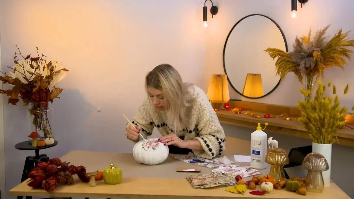 Frau bastelt mit Kürbis