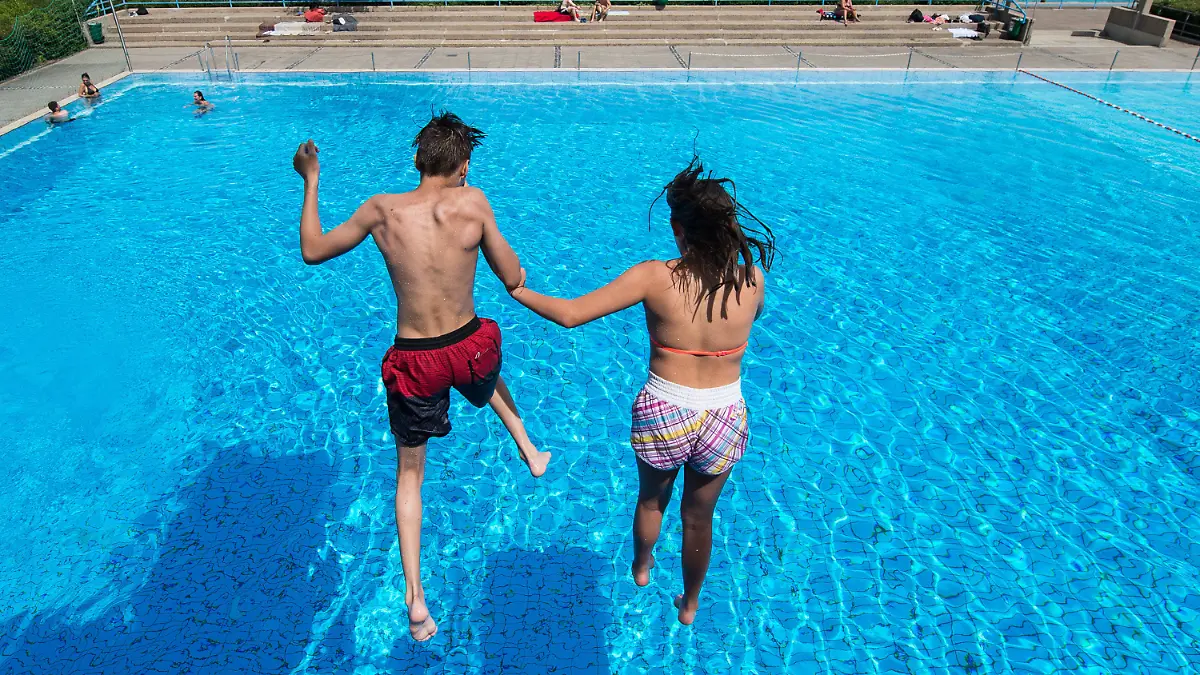 Ein Junge und ein Mädchen springen am 21.06.2017 in einem Freibad in Hannover (Niedersachsen) von einem Sprungturm ins Wasser. In Niedersachsen beginnen heute die Sommerferien. (zu dpa «Niedersachsen und Bremen starten als erste Länder in Ferien» vom 21.06.2017) Foto: Silas Stein/dpa +++(c) dpa - Bildfunk+++
