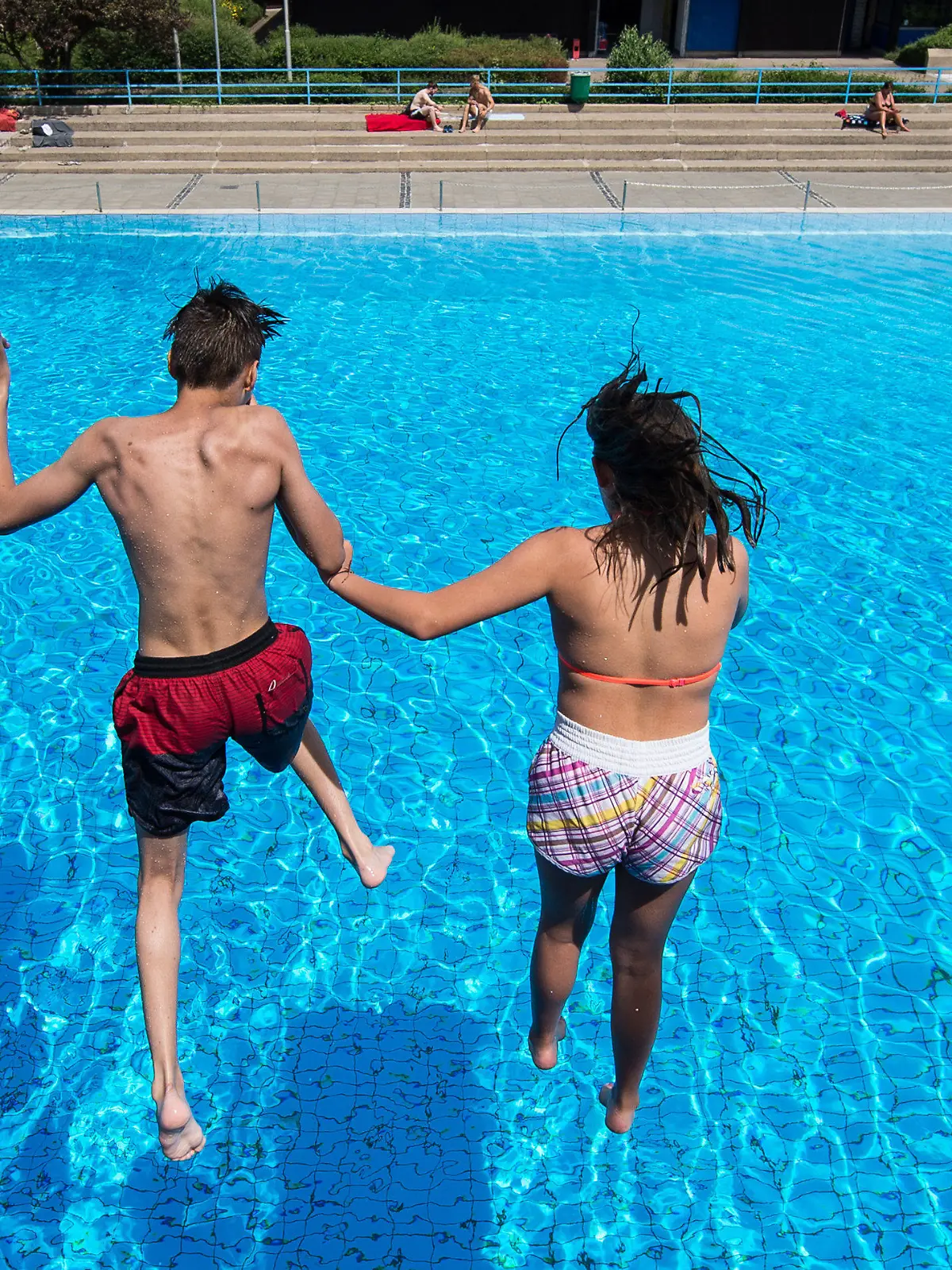 Ein Junge und ein Mädchen springen am 21.06.2017 in einem Freibad in Hannover (Niedersachsen) von einem Sprungturm ins Wasser. In Niedersachsen beginnen heute die Sommerferien. (zu dpa «Niedersachsen und Bremen starten als erste Länder in Ferien» vom 21.06.2017) Foto: Silas Stein/dpa +++(c) dpa - Bildfunk+++