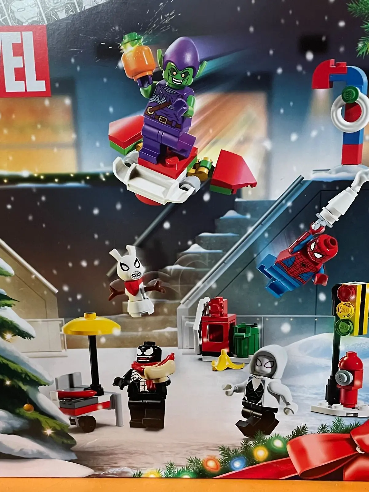 Packung des Lego Spider-Man Adventskalenders 2024 steht auf einem orangen Tischchen.