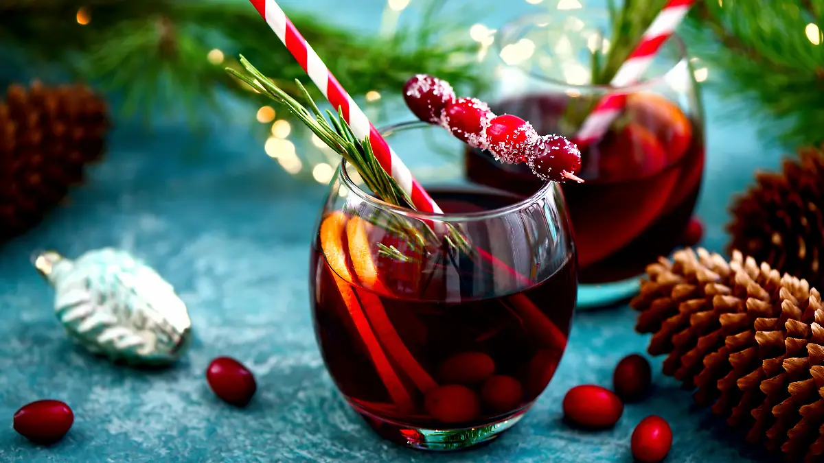 Ein roter Cocktail umgeben von winterlicher Dekoration.