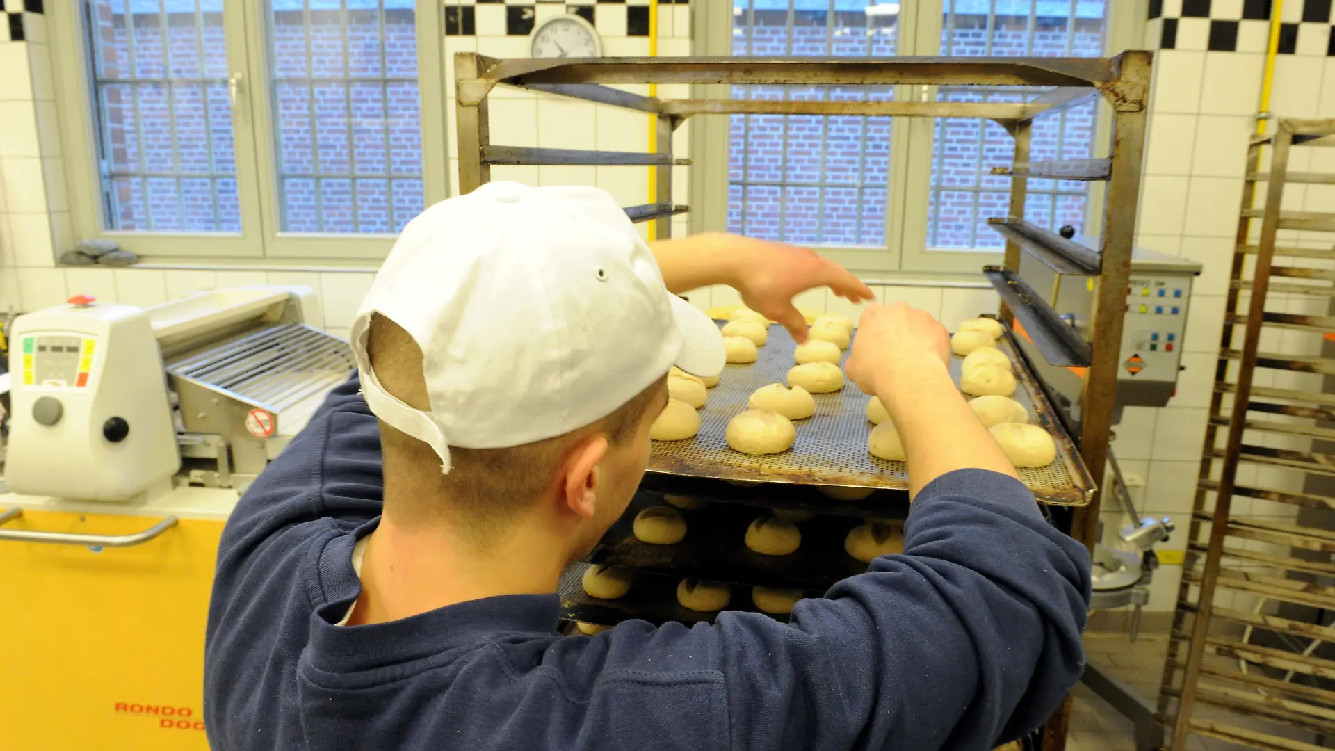 Ein Auszubildender arbeitet am 22.01.2014 in der Bäckerei der Justizvollzugsanstalt in Neumünster (Schleswig-Holstein). Der Azubi ist einer von momentan 382 Häftlingen. 307 gehen einer Beschäftigung nach, 377 könnten es maximal. Junge Häftlinge halten die Lehre hinter Gittern sogar für gründlicher als draußen. Foto: Carsten Rehder/dpa (Zu dpa "Nach Ausbildung im Gefängnis draußen richtig Gas geben" vom 25.01.2014)