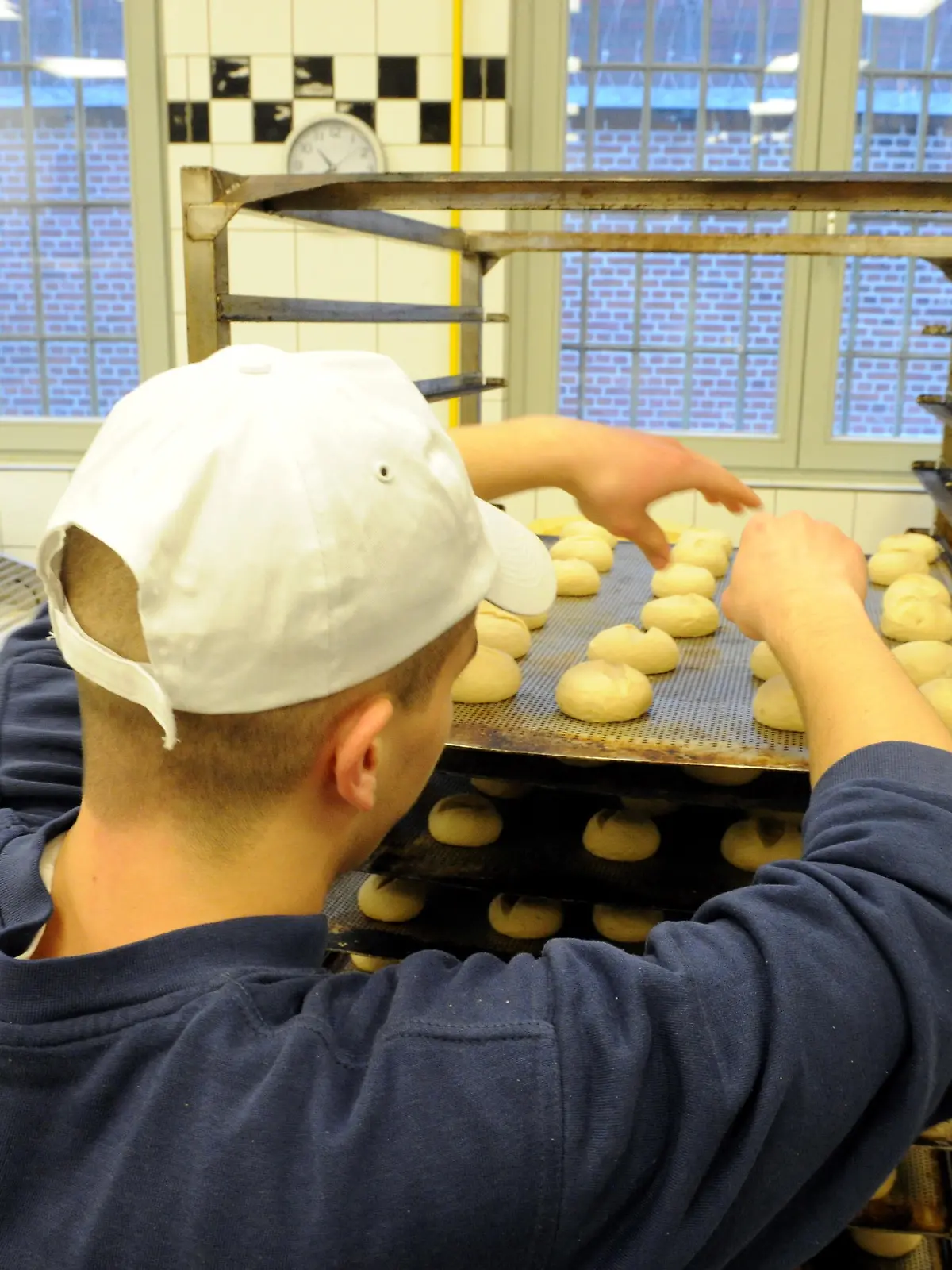 Ein Auszubildender arbeitet am 22.01.2014 in der Bäckerei der Justizvollzugsanstalt in Neumünster (Schleswig-Holstein). Der Azubi ist einer von momentan 382 Häftlingen. 307 gehen einer Beschäftigung nach, 377 könnten es maximal. Junge Häftlinge halten die Lehre hinter Gittern sogar für gründlicher als draußen. Foto: Carsten Rehder/dpa (Zu dpa "Nach Ausbildung im Gefängnis draußen richtig Gas geben" vom 25.01.2014)