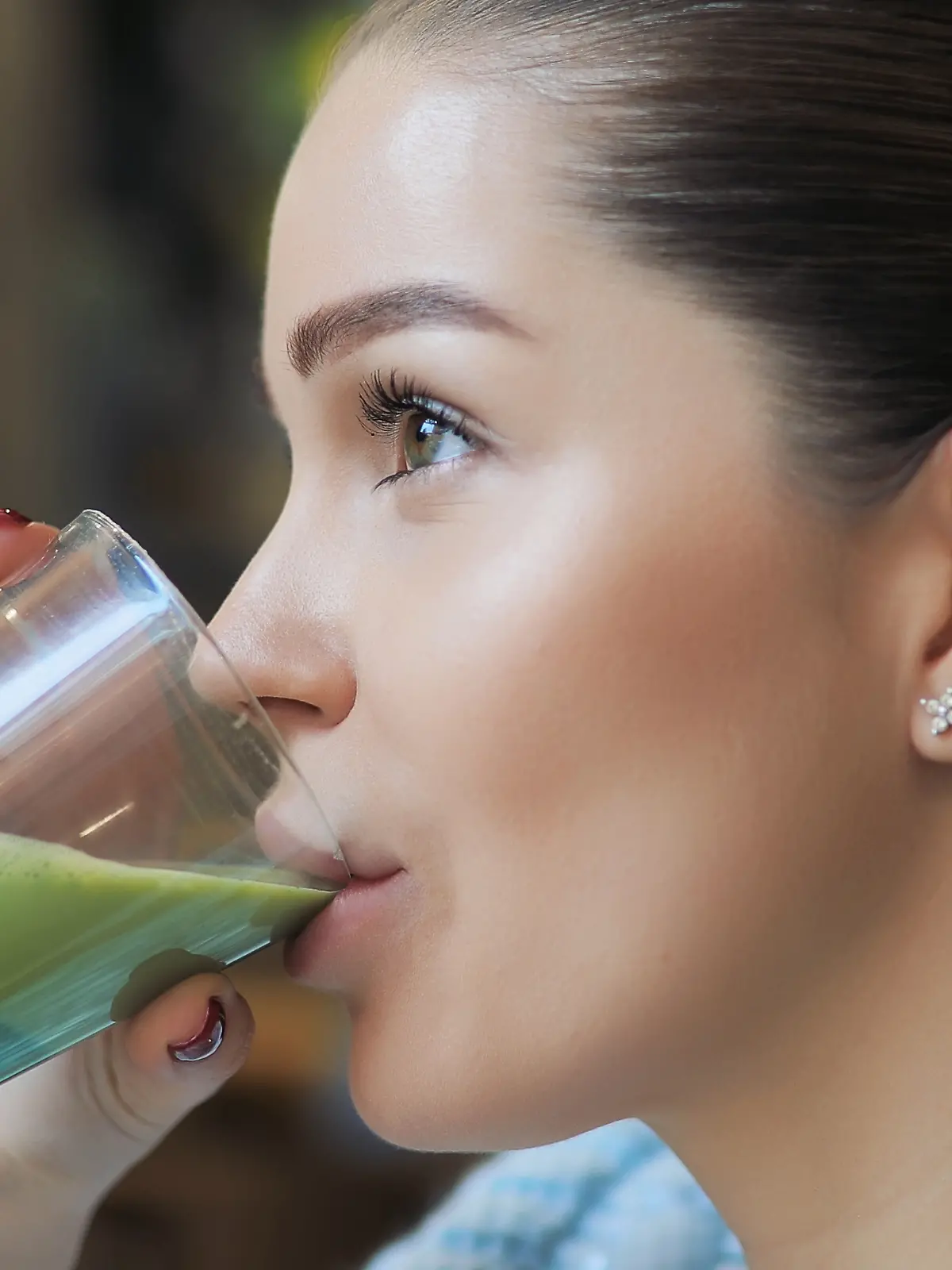 Frau trinkt grünen Matcha-Latte 