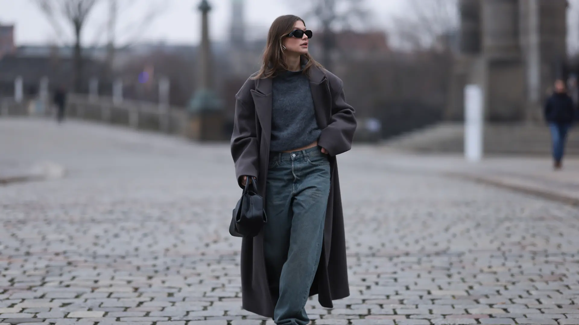 Sophia Geiss zeigt einen einfachen und stylischen Herbst-Winter-Look: Weite Jeans mit grauem Pullover und Mantel