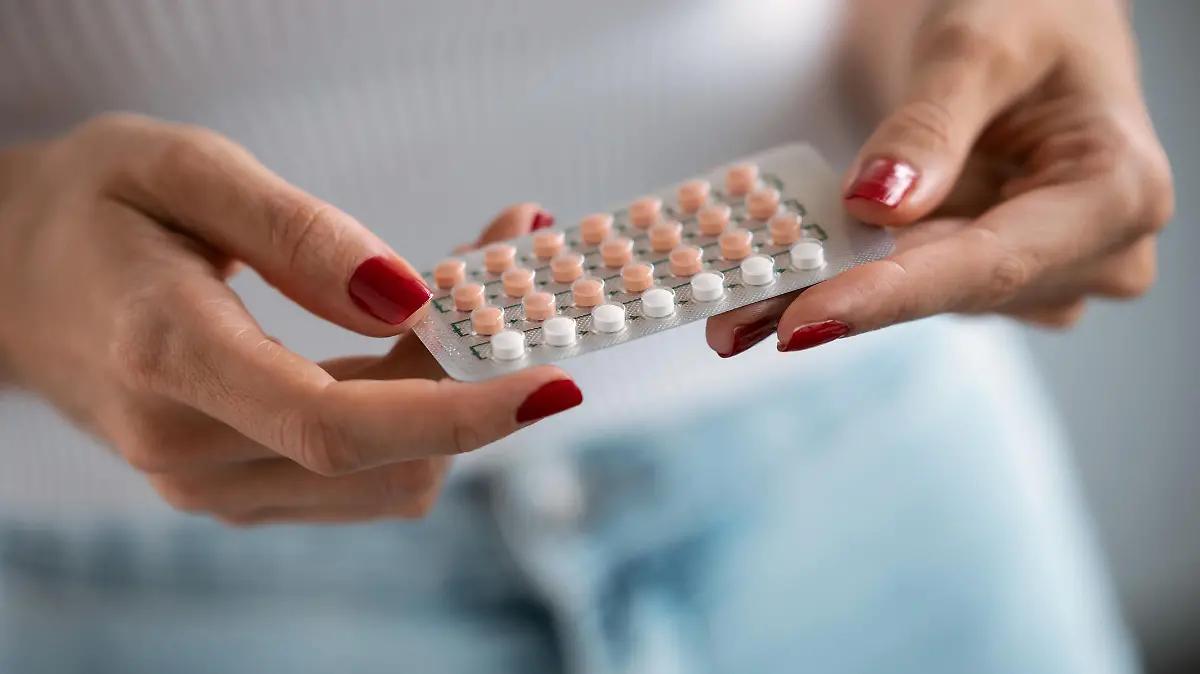 Close-up of woman holding a contraceptive pills. Concept of contraception methods.