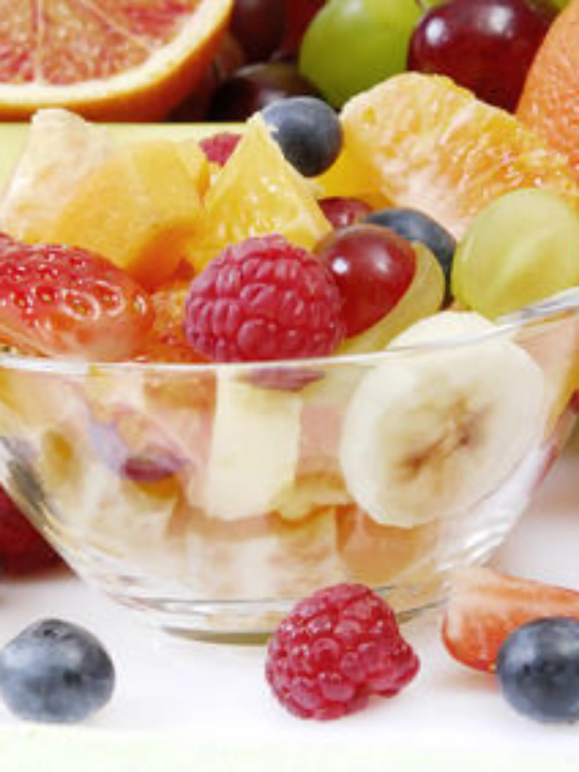 Obstsalat in einer Glasschale arrangiert mit frischen ganzen Früchten