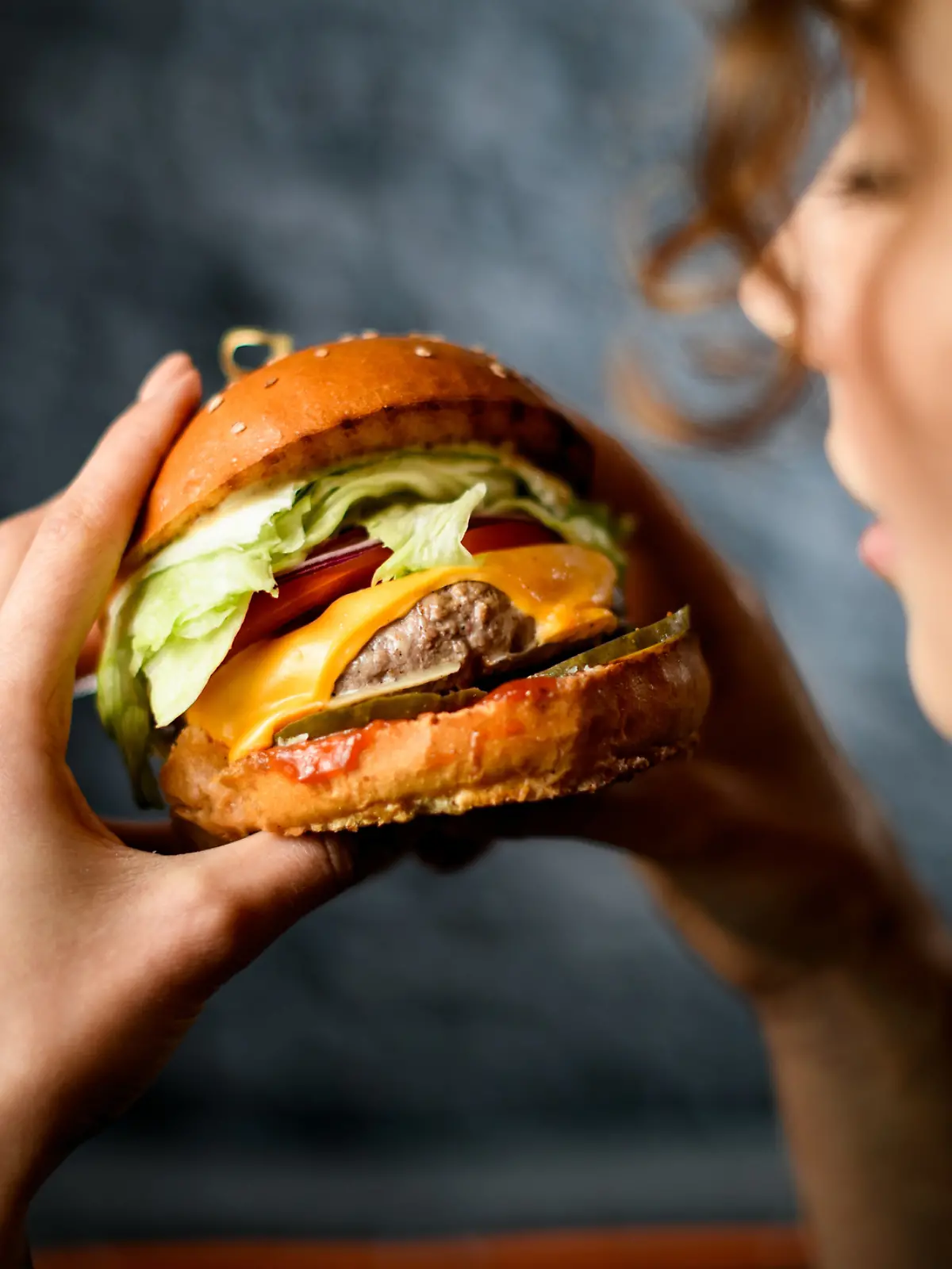 Frau beißt in Burger. 