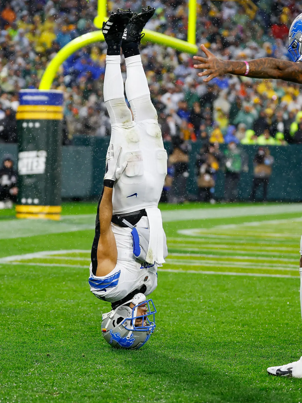 Amon-Ra St. Brown feiert seinen Touchdown mit einem Kopfstand.