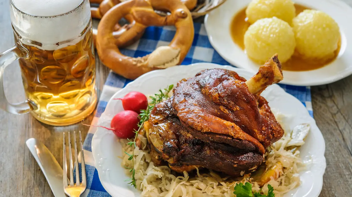 Appetizing Bavarian roast pork knuckle with dumplings and sauerkraut. Oktoberfest