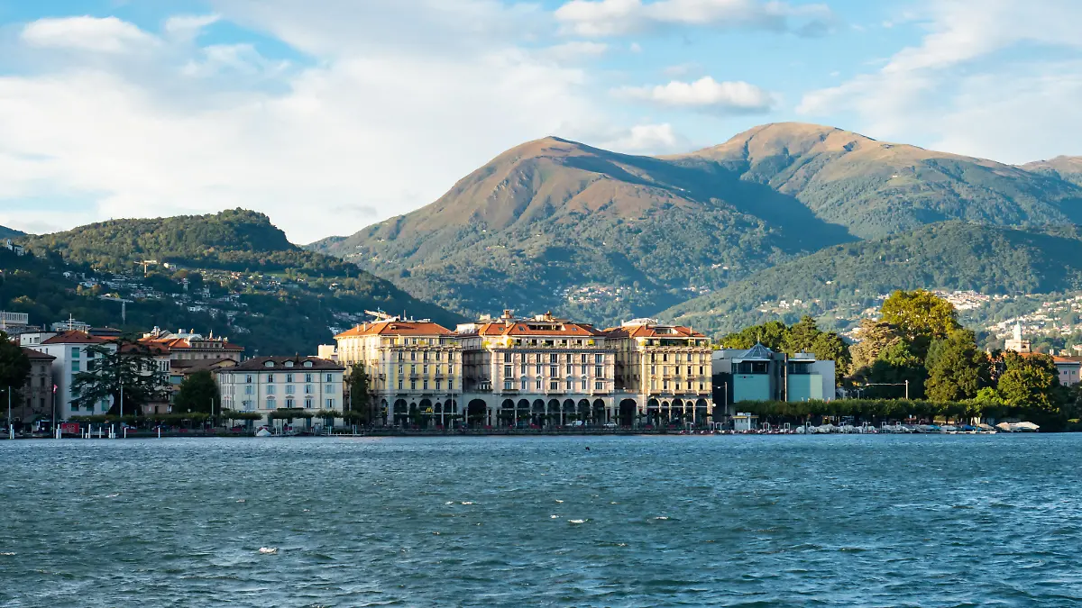 Skyline of the city of lugano situated in Ticino, Switzerland. Historic buildings surrounded by hills and mountains. Perspective from the lake.